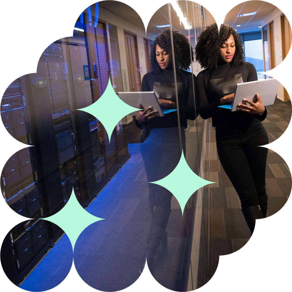 Une personne travaillant sur un ordinateur portable dans une salle de serveurs.